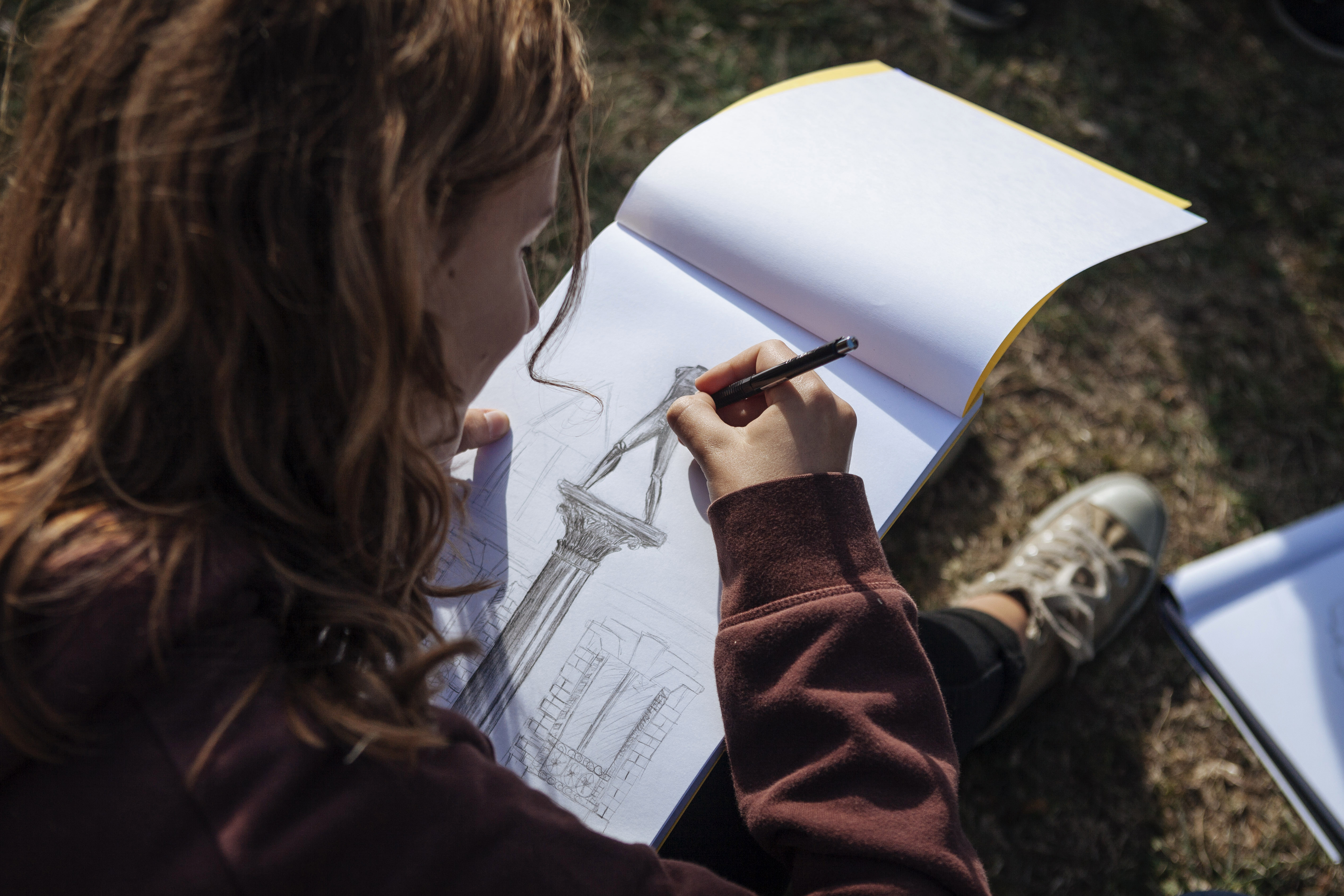 Adolescente dessinant L'homme qui marche sur colonne