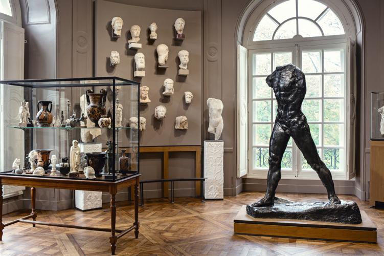 Sculpture de L'Homme qui marche en bronze, entouré de sculptures antiques et situé dans la salle "Rodin et l'antique" au musée Rodin