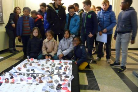Les enfants rassemblés présentent leurs travaux dans la salle du musée